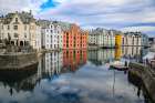 Alesund, Norway. Canal with colorful painted houses, boats, marina, sailor statue. Art Print
